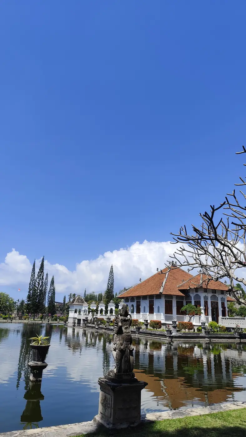 Statue and pavilion reflected in the pond at Taman Ujung Water Palace